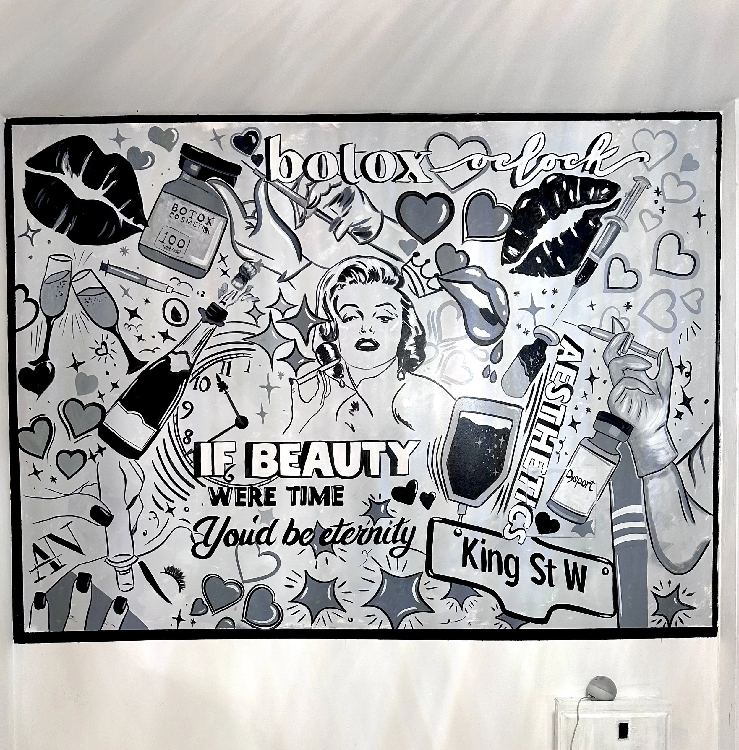 Black and white mural illustrating beauty treatments, including a woman with vintage makeup, Botox medications, syringes, lips, champagne glasses, a clock, beauty bottles, and makeup tools, with text referencing Botox and beauty.